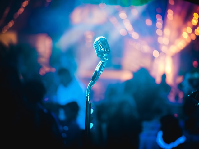 Performer singing into a microphone on stage